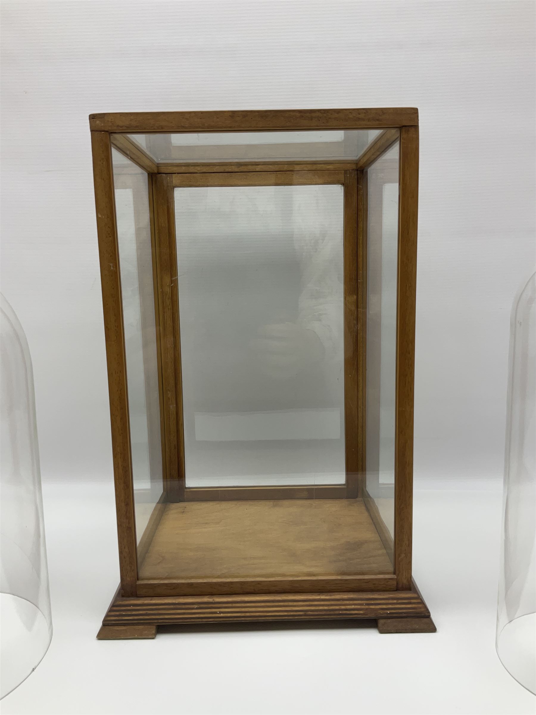 Tabletop glass display cabinet, with hinged door, together with two glass domes