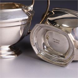 Art Deco three-piece silver tea service, comprising teapot with removable tea strainer, open sucrier and milk jug, all of hexagonal form, the teapot with wooden handle and finial, all hallmarked James Deakin & Sons, Sheffield 1925, together with a matched pair of silver sugar tongs, hallmarked