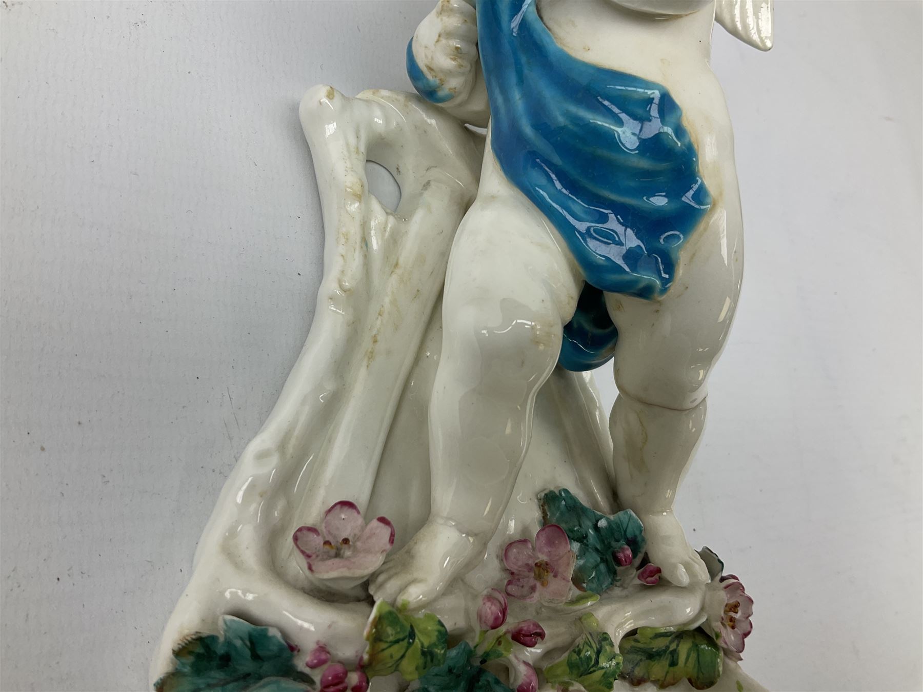 Victorian wall pocket by Moore Brothers retailed by T.Goode modelled as a semi nude white glaze cherub with turquoise ribbon, with encrusted floral decoration, the reverse stamped ‘T.Goode & Co.’, H32cm