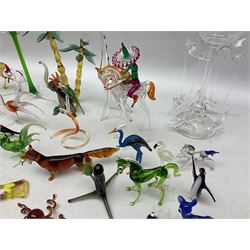 Quantity of hand blown glass figures of animals, to include example modelled as an elephant beneath trees bearing fruit, stylised cockatoo perched upon spiralled branch, giraffe, dogs with their leg cocked beneath streetlight, fox with catch in its mouth, octopus, various birds and dogs, penguins, fish, deer etc, tallest H27cm