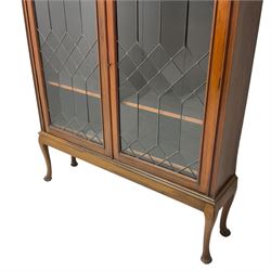 Early 20th century walnut display cabinet, projecting moulded cornice over two lead glazed doors, the interior fitted with three adjustable shelves, on cabriole supports