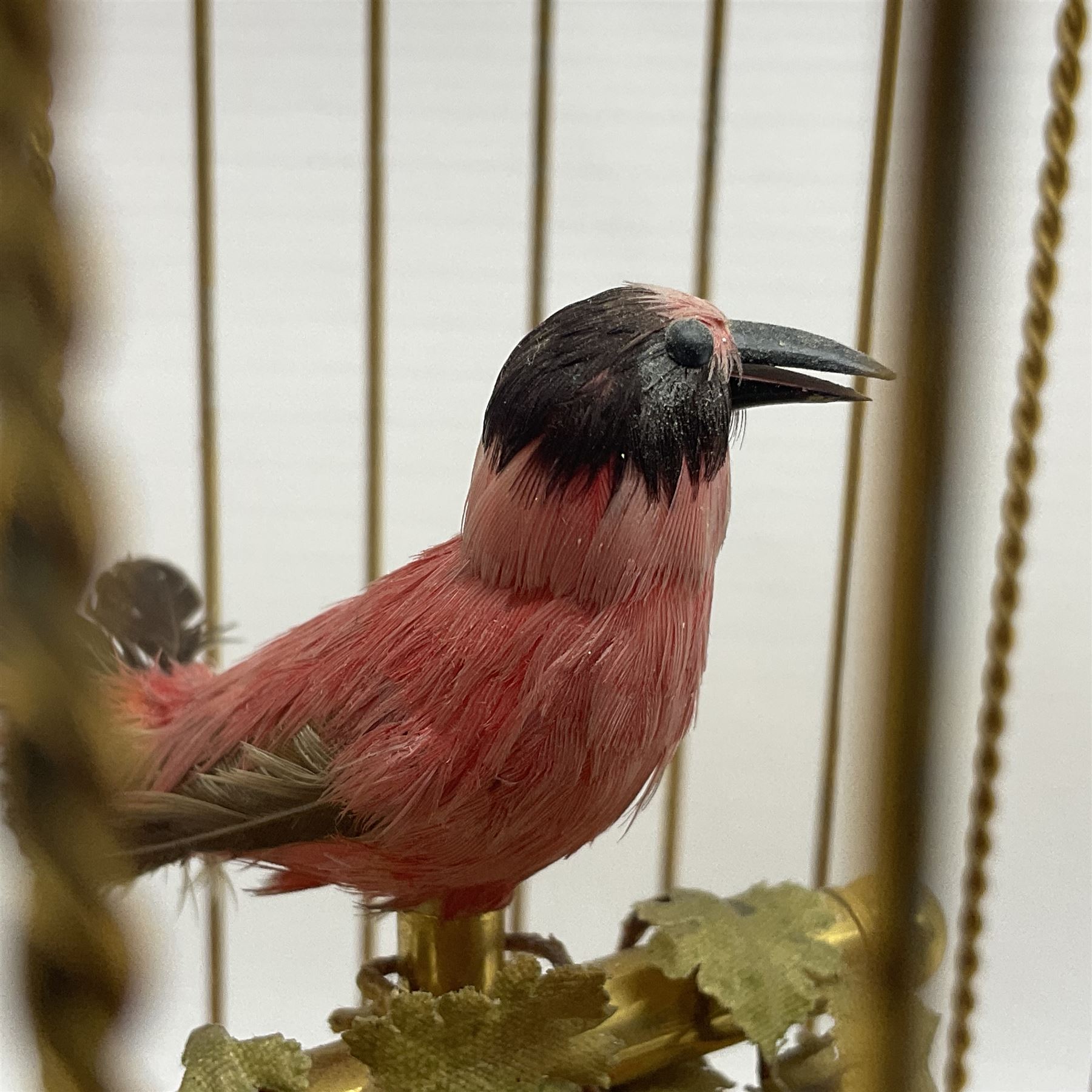 Swiss Reuge Music bird cage automaton music box, the bird with articulated head and beak, in a gilt brass cage, with a glass dome and stand, H30cm