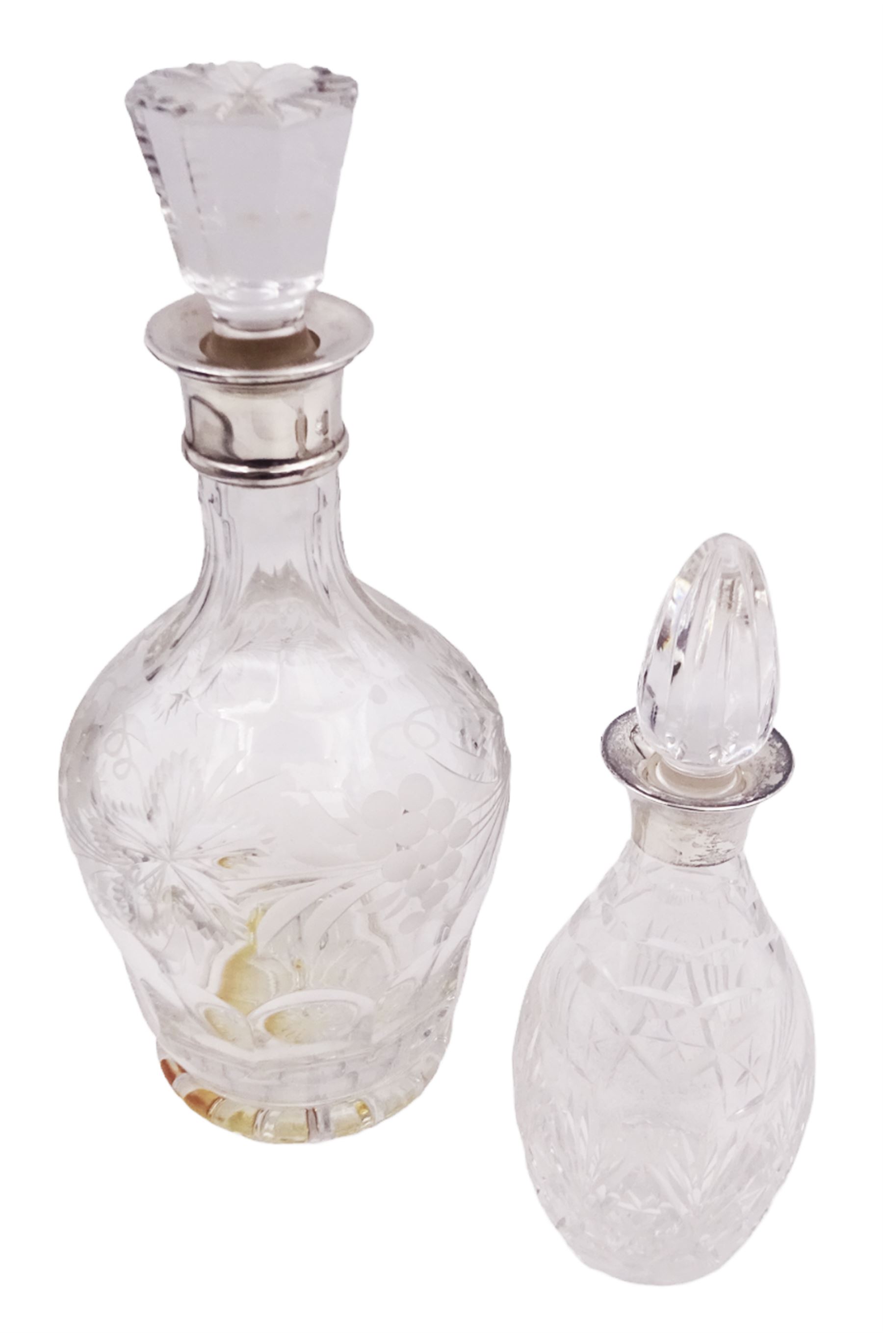 Two modern silver mounted decanters, the first example with etched and cut fruiting vine decoration to glass body, with faceted stopper, hallmarked C J Vander Ltd, Birmingham 1980, the second smaller example, with oval cut decoration and flambe type stopper, hallmarked S J Rose & Son, Birmingham 1985, tallest H28.5cm