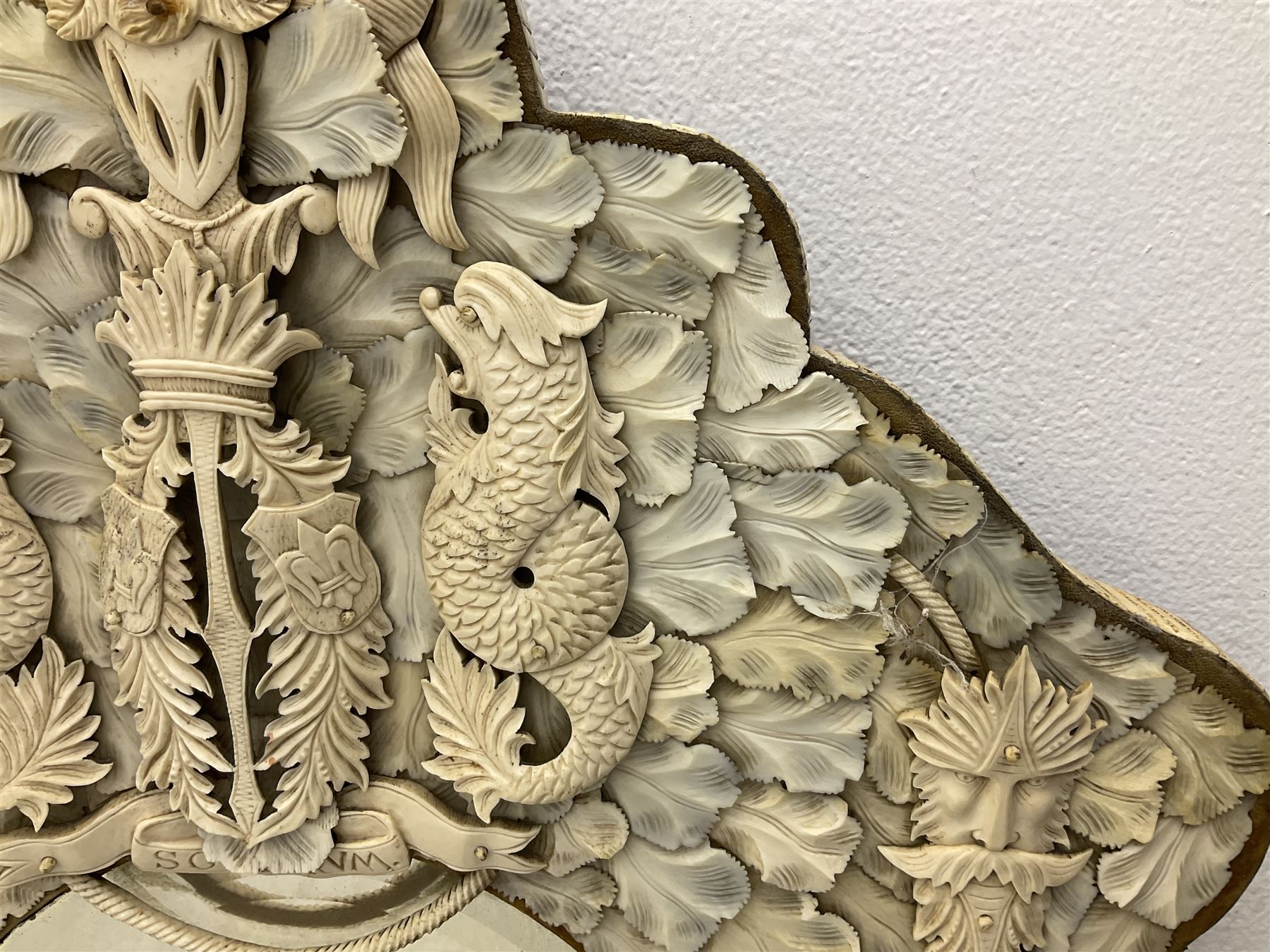 Pair 19th century French Dieppe bone and ivory wall mirrors, the oval bevelled mirror plates within rectangular frames with shaped tops, profusely decorated with ivory leaves, further detailed with carved bone armorial type crest inscribed 'SGOTORVM', putti, fish and mask heads, H81cm W48cm