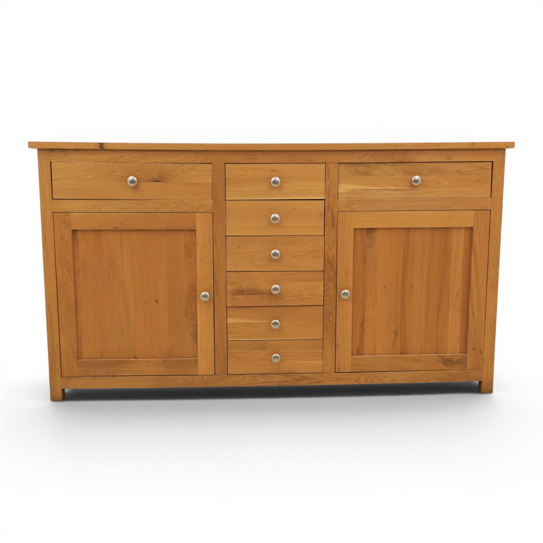 Solid oak sideboard fitted with drawers and cupboards, central bank of six drawers, metal pulls 