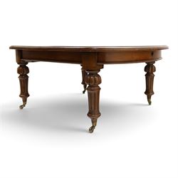 Large Victorian oak extending dining table, the rectangular top with rounded corners and moulded edge, plain frieze over large turned lobed and fluted supports terminating to brass cups and castors, with two additional leaves
