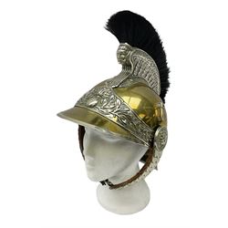 Early 20th century French mounted gendarme's helmet, brass with nickel-silver mountings, broad band embossed with fused grenade, high comb with the face of the gorgon Medusa at the peak and with a black horse hair crest, plume socket at the left, leather-backed nickel-silver chin scales with lion mask mounts.