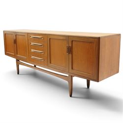 G-Plan - 'Fresco Long John' teak mid 20th century sideboard, a central bank of four drawers, flanked by twin cupboard doors, with recessed handles, on a tapering supports 