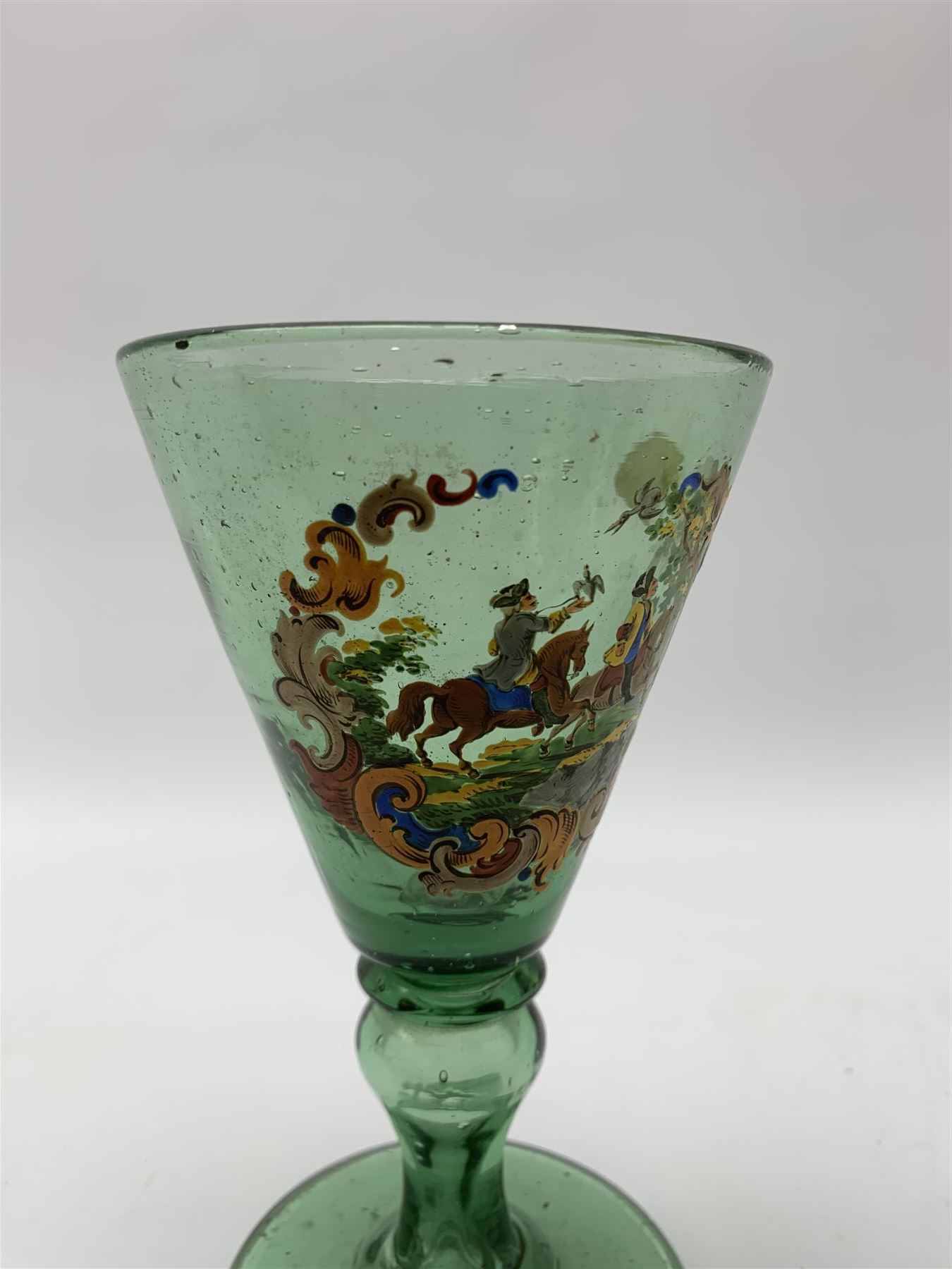 19th century bohemian green glass wine glass, the funnel bowl decorated in enamells with a Historismus hunting scene in the manner of Egermann & Lobmeyr, upon a baluster stem and circular foot, H14.5cm