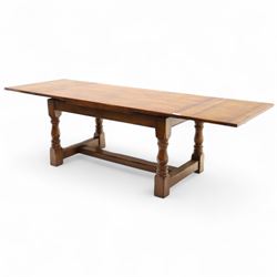 20th-century good quality solid oak extending refectory table, planked, constructed rectangular top with two extending leaves on the underside above a plain frieze raised on four turned baluster supports united by stretchers on block feet, 260cm extended