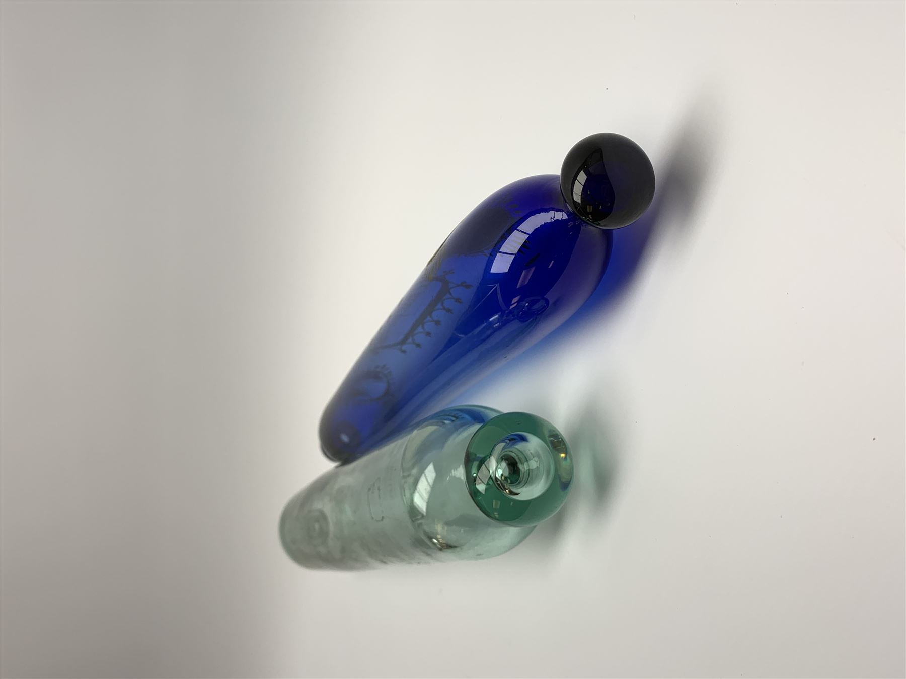 19th century Bristol blue glass rolling pin, with printed and gilt decoration of a schooner, crossed union flags, and inscription 'I wish you well', L36cm, together with another 19th century green glass example, L39cm