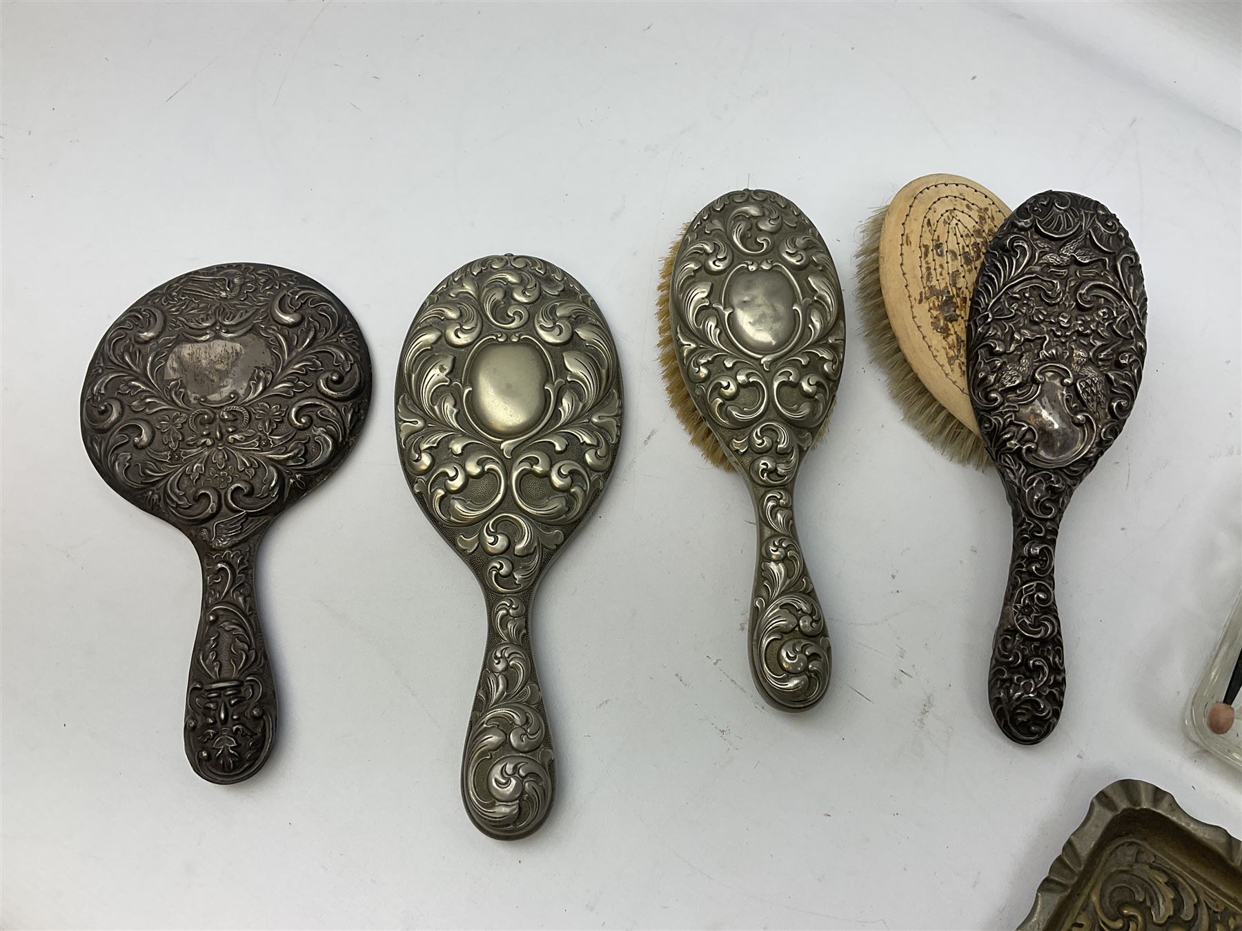 Glass dressing table tray, scent bottles and lidded bowl, metal mounted foliate design hair brushes and handheld mirrors etc