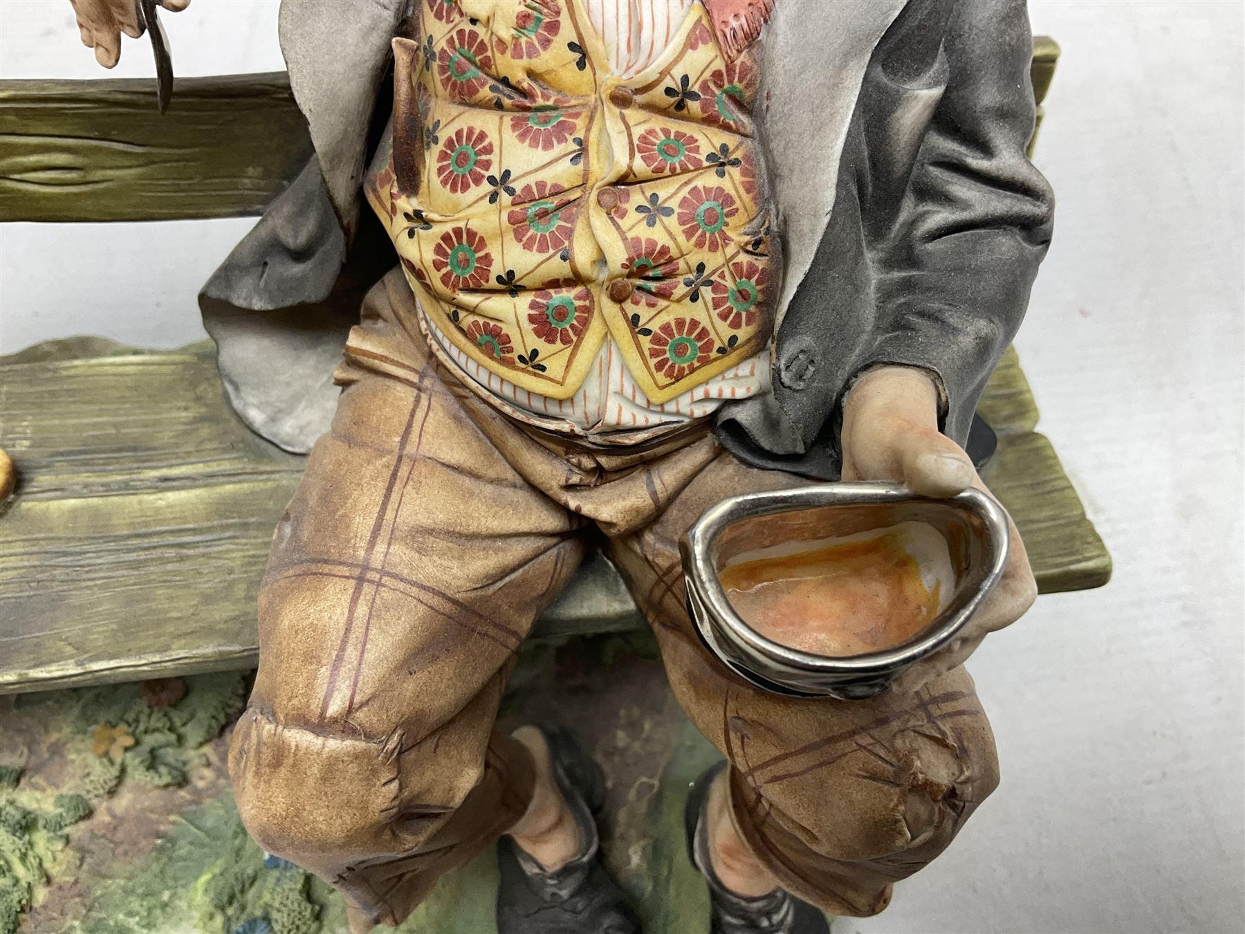 Two Capodimonte figures, comprising The Watchmaker by Curiase and Tramp Seated on a Bench, created by D.Bonalberti, tallest example H24cm