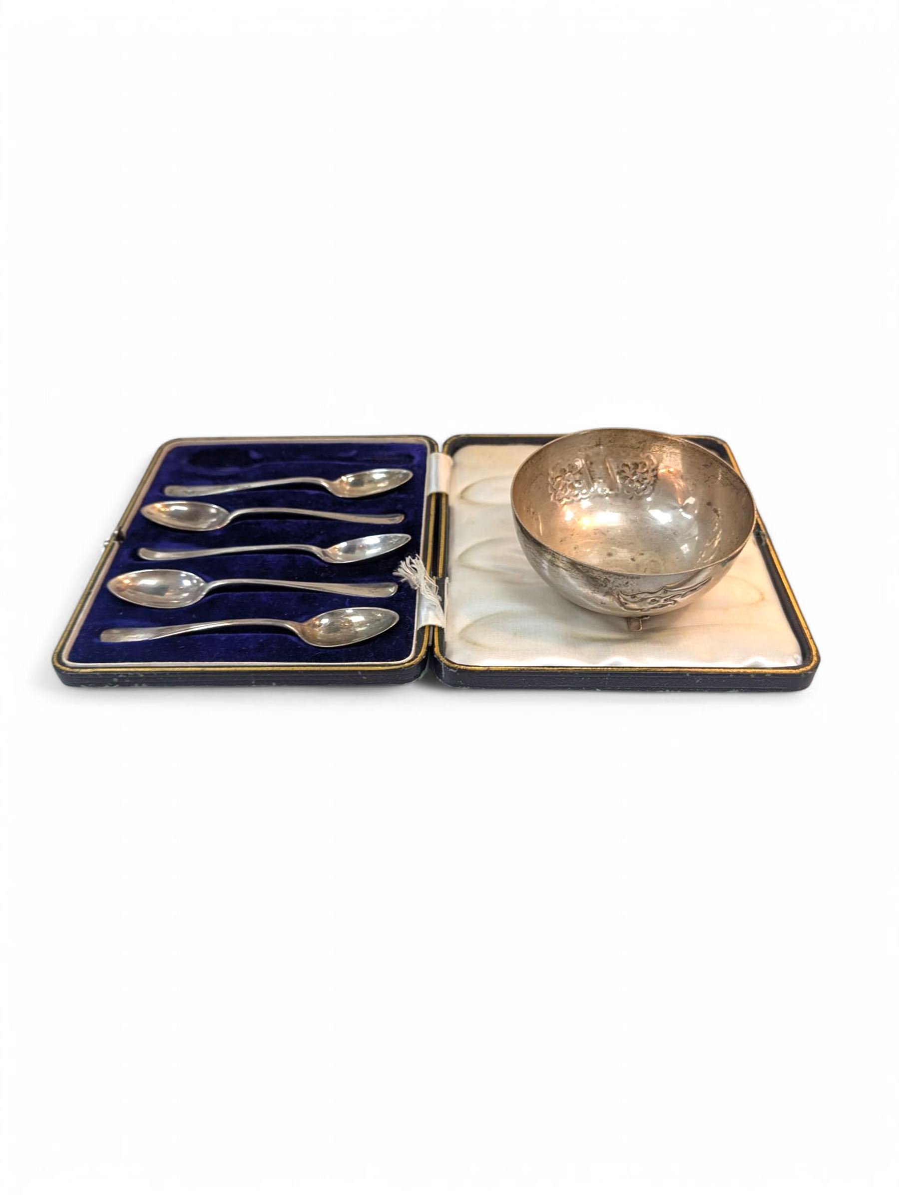 Scandinavian silver bowl, with embossed decoration upon three pad feet, stamped 830s, together with five cased silver coffee spoons, hallmarked, bowl H5cm