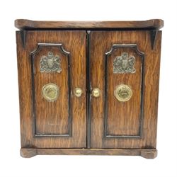 Victorian oak smoker's cabinet / cigar and cigarette box modelled in the form of a two door safe, the hinged twin doors with applied Royal crests opening to reveal one long drawer over two short drawers, H23cm