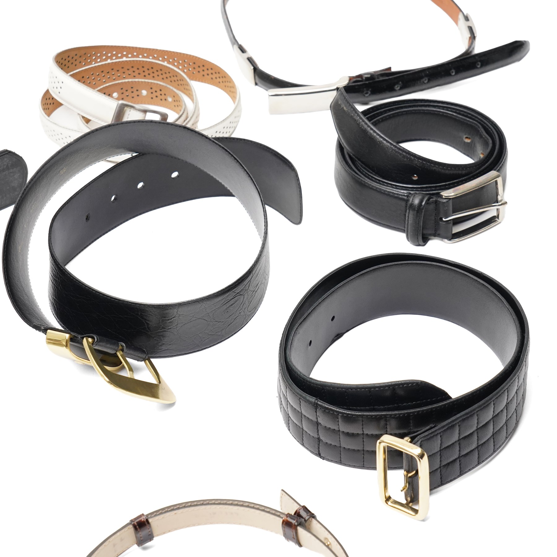 Collection of belts, including white Nike Golf leather belt with oval green and silver Nike swoosh buckle, white Nike leather belt in perforated pattern, black Aigner crocodile-embossed leather belt with large gold buckle, black Jaeger quilted leather belt with rectangular gold buckle, etc (10)
