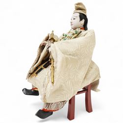 Two early 20th century Japanese 'Musha-ningyo' or Warrior Doll figures, costumed with distinctive armour and attributes, the first seated on lacquered red stool the other on a taxidermy rug, seated figure H44cm (2)