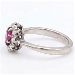 White gold ruby and diamond cluster ring, single oval cut ruby of approx 0.45 carat, surrounded by eight single cut diamonds, stamped 18ct, total diamond weight approx 0.15 carat