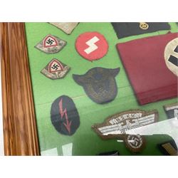 Framed display of thirty-four WWII German cloth badges including Luftwaffe pilot, Paratrooper, Afrikakorps cuff title, sleeve insignia for 'SS' Foreign Volunteers, various breast eagles including Luftwaffe, Army etc, RAD badges, Party Armband, rank and trade insignia, cap insignia etc; 40 x 50cm in modern pine frame