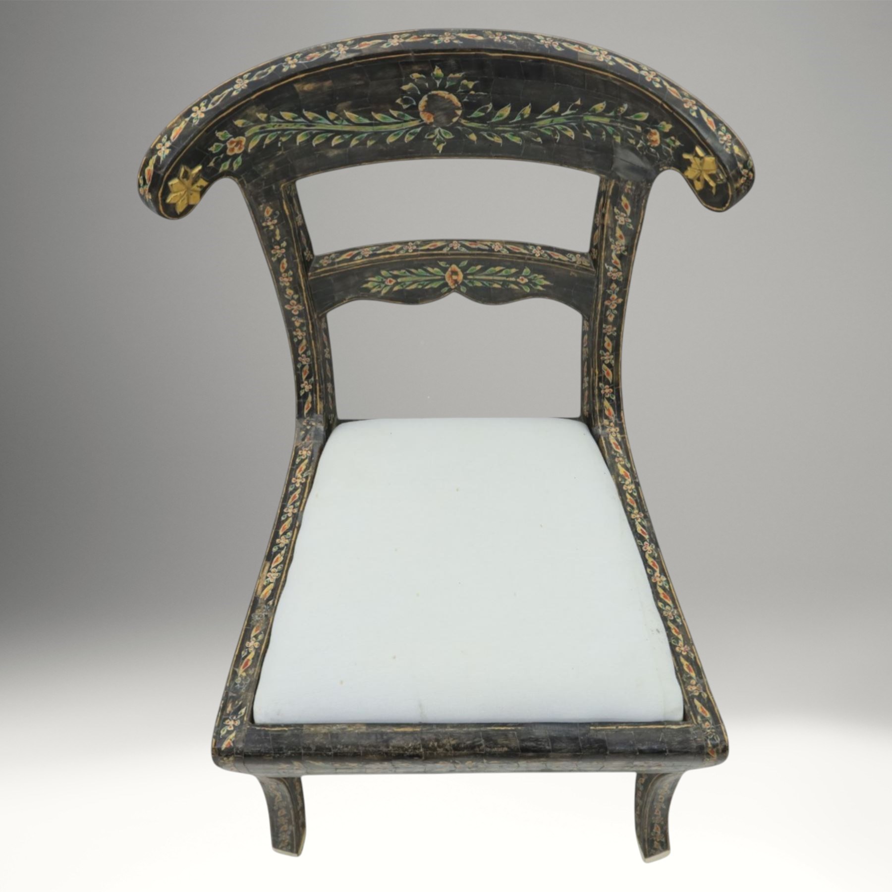 Early 20th century Anglo-Indian painted and inlaid armchairs, each with shaped top rail decorated with polychrome floral motifs above turned spindle galleries, shaped open arms and upholstered seats, on square supports with similar painted decoration