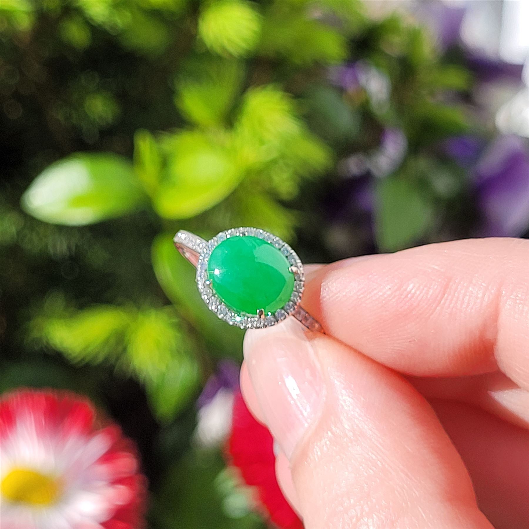 Platinum jadeite and diamond cluster ring, single oval cabochon cut jadeite of 2.20 carat, surrounded by round brilliant cut diamonds and diamond set shoulders, stamped Plat