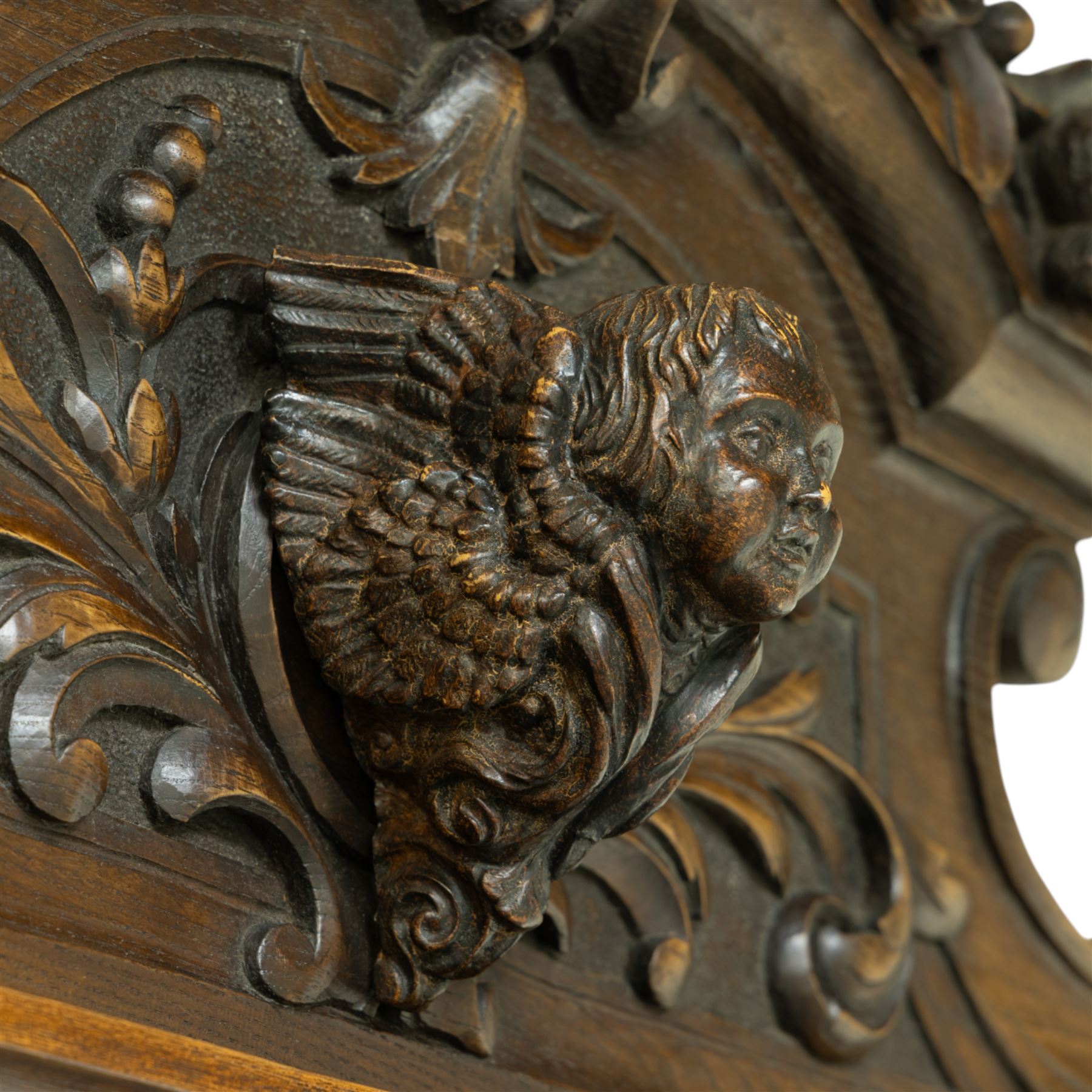 Large mid-19th-century Victorian rococo revival carved oak overmantel mirror, the rectangular mirror frame carved in high relief,  arched and scrolled pediment surmounted by a central foliate spray with acanthus scrolls above a finely carved classical mask, frieze decorated with symmetrical  acanthus scrolling, vertical uprights carved with trailing foliage, flowers, and ribbon-tied elements, terminating on a square supports 
