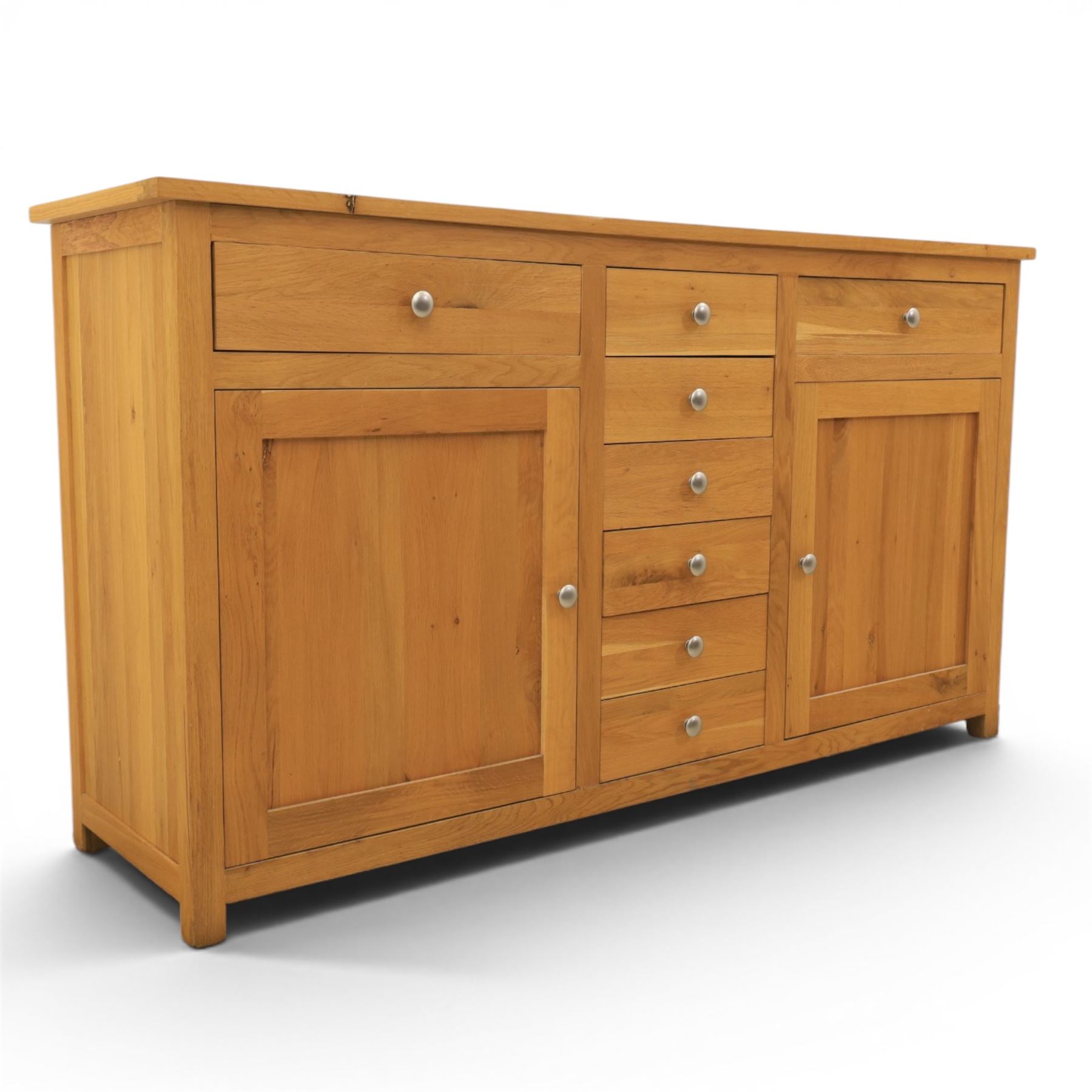 Solid oak sideboard fitted with drawers and cupboards, central bank of six drawers, metal pulls 