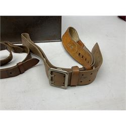 Assorted militaria including ten leather or canvas cartridge and other belts, maroon beret with 17th Lancers cap badge, modern bullet mould, leather and brass shot flask, two knives, shell cases, boomerang etc; in tin deed box