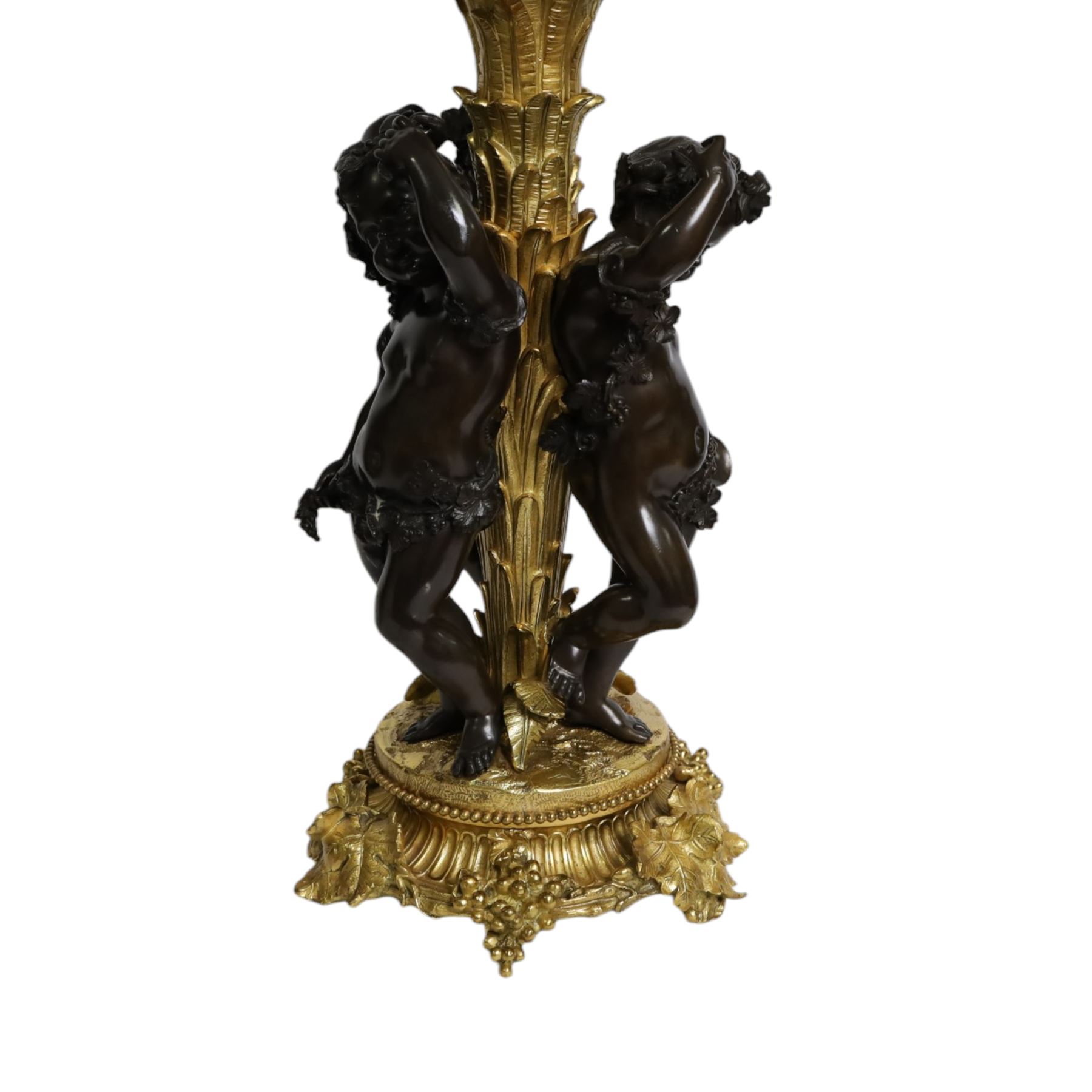 Louis XVI style gilt table lamp, the central column decorated with acanthus leaves, surrounded with three putti with vine leaf crowns, upon a circular base adorned with grape and vines, with shade, H64cm