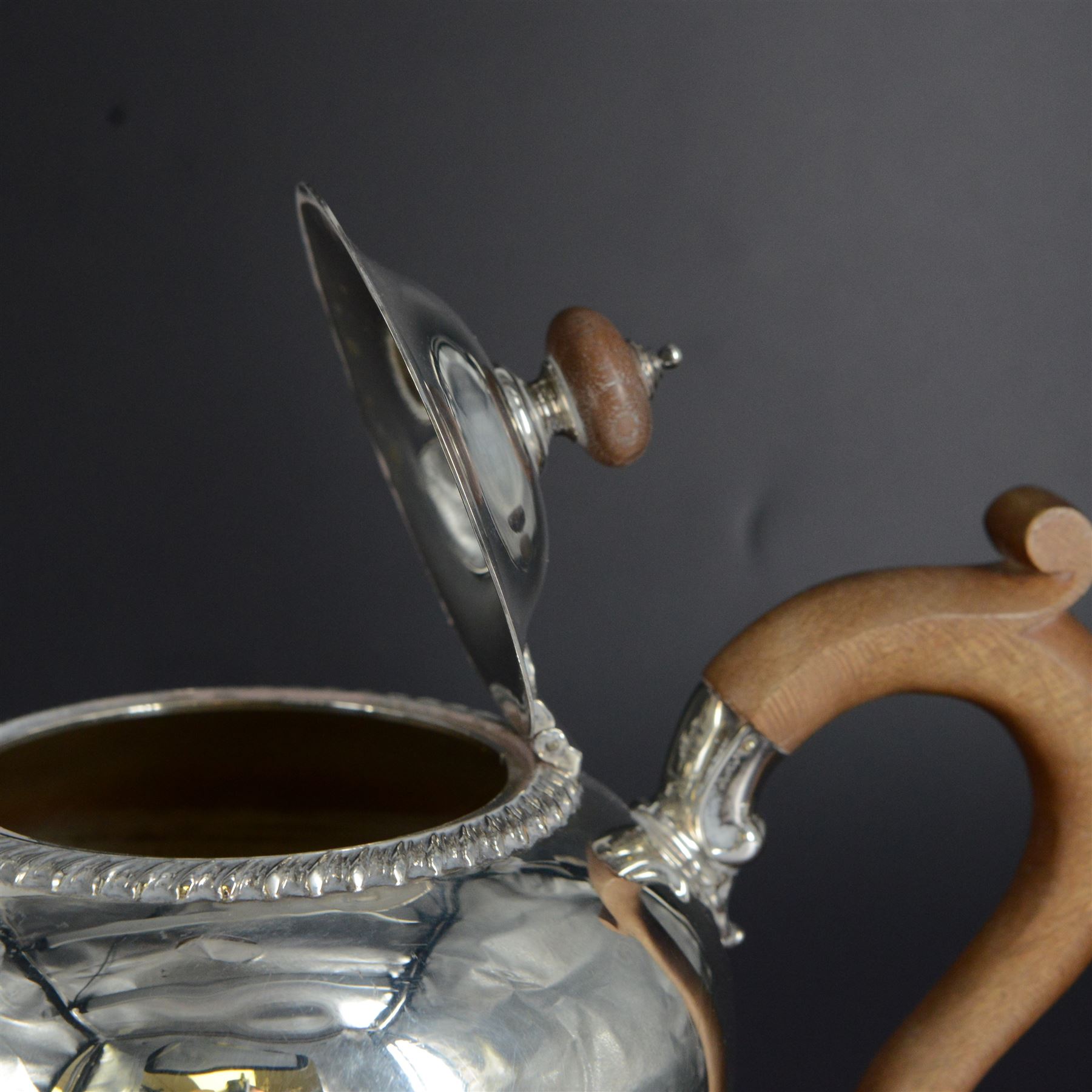 Modern three piece silver tea service, comprising coffee pot, teapot and milk jug, each of spherical form, upon circular domed foot, the teapot and coffee pot with wooden handles, the teapot with wooden finial, hallmarked Bryan Savage, London 1975, coffee pot H29cm