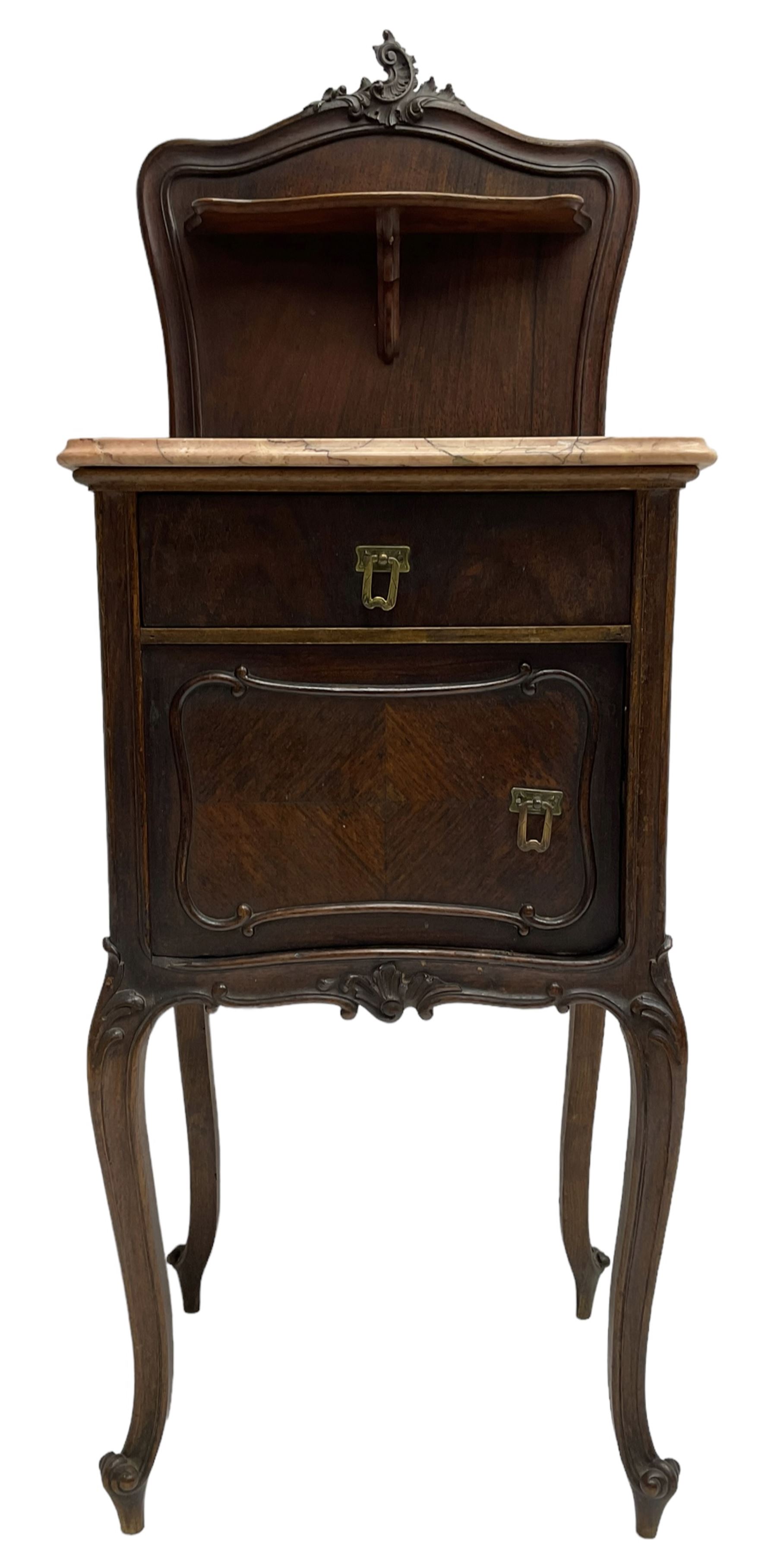 Late 19th to early 20th century walnut bedside pot cupboard, the shaped raised back with carved C-scroll pediment, pink variegated marble top, fitted with single drawer and cupboard, foliage carved cabriole supports with scroll carved terminals