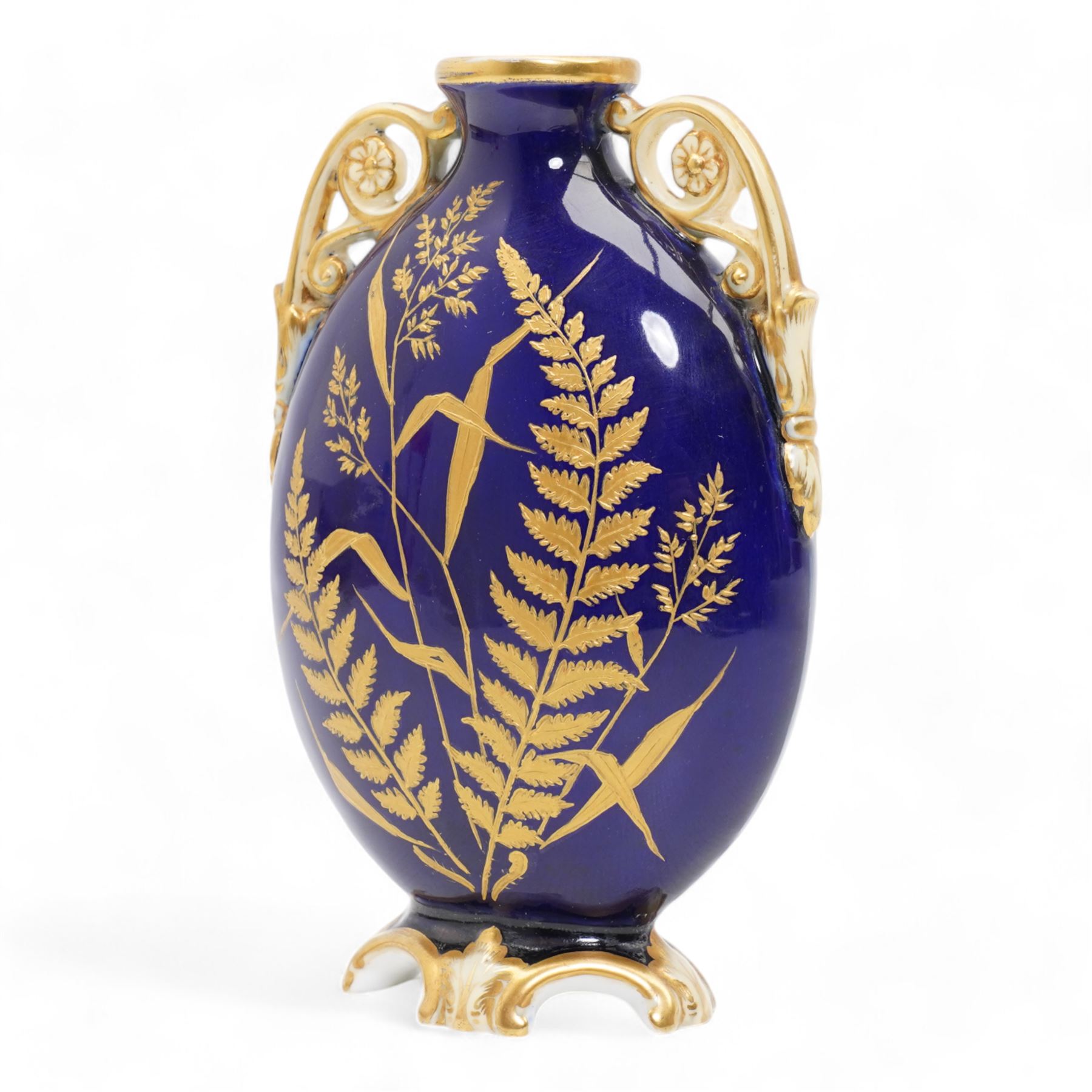 Early 20th century Royal Worcester loving cup, circa 1906, painted with a view of the River Severn and flowers to the reverse, H13cm, Grainger & Co. Worcester twin handled vase, the oval body painted in the Aesthetic style with ferns and grasses in gilt, against a cobalt blue ground, with scrolled handles and quatrefoil foot, H17cm (2)
