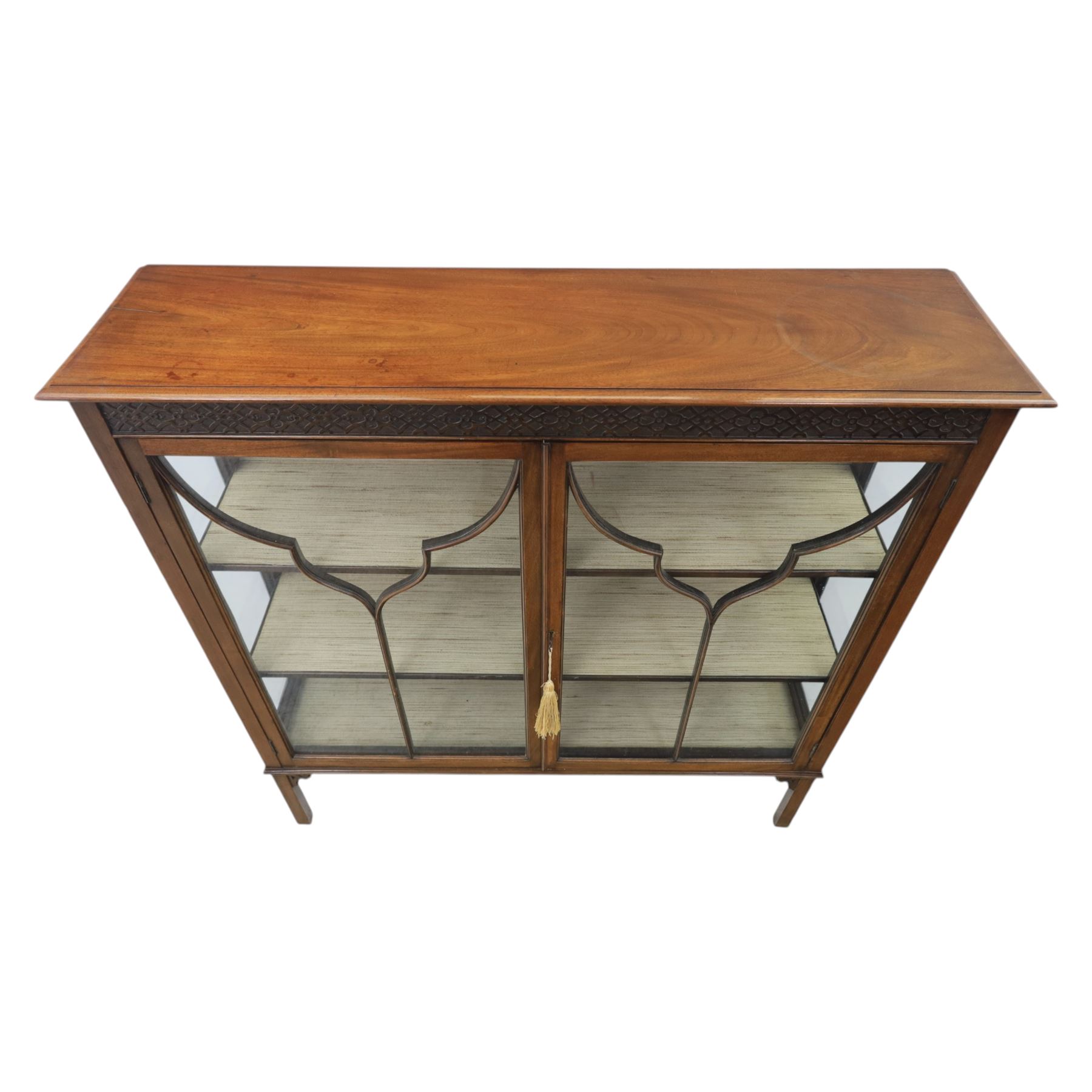 Edwardian mahogany display cabinet, blind-fretwork frieze over astragal glazed doors, square legs with fretwork detail