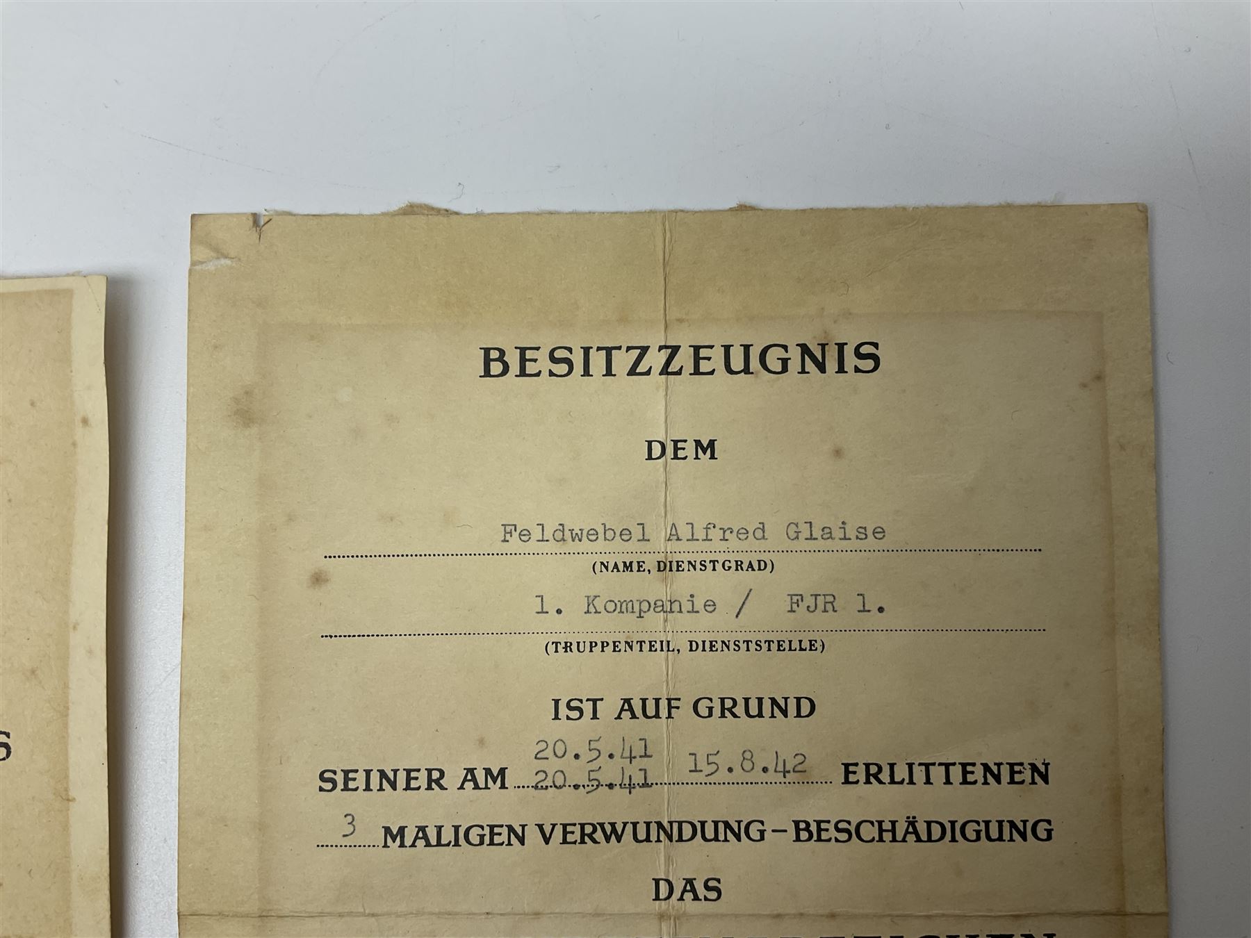 Three German documents dated 1942 - Gold Cross award to Major Ludwig Osterkampf; and Crete wound certificate and cuff title certificate awarded to Feldwebel Alfred Glaise; all unframed (3)