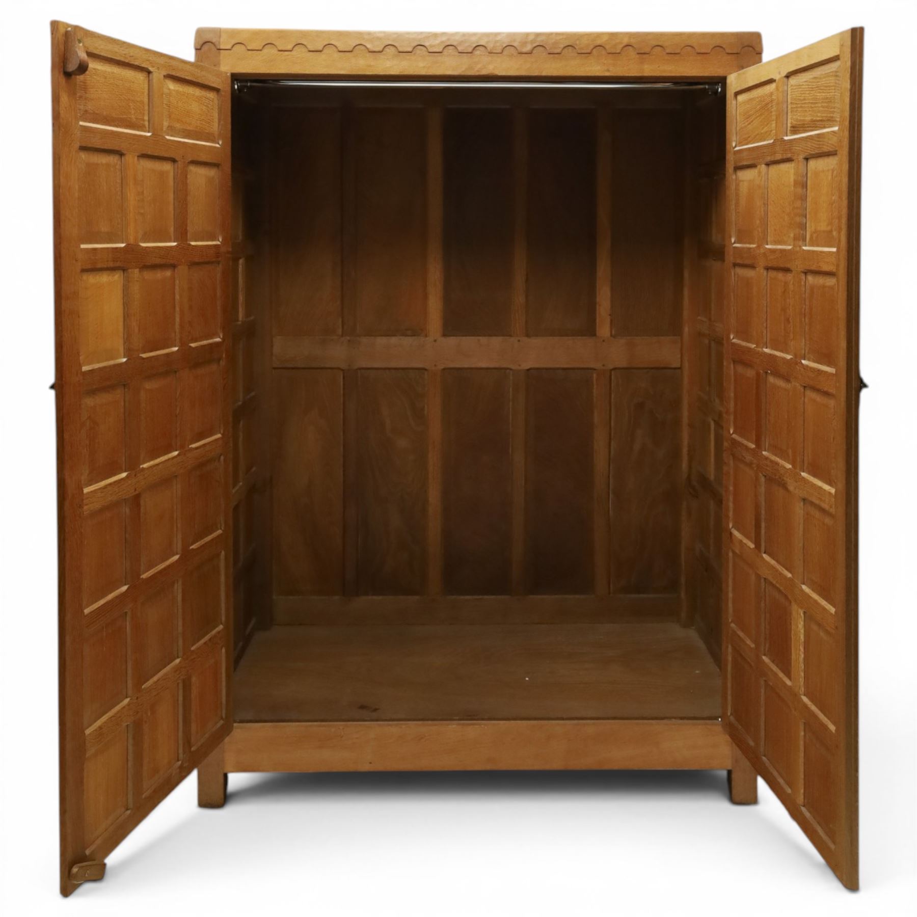 Mouseman - early-to-mid-20th century panelled and adzed double wardrobe, the arcade carved cresting rail over two panelled doors, with wrought metal hinges and latch, deep relief carved mouse signature, the interior fitted with hanging rail, by the workshop of Robert Thompson of Kilburn