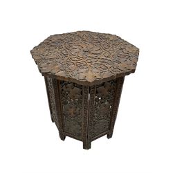 Anglo-Indian carved hardwood occasional table, octagonal top carved profusely with trailing branches and foliage, on folding base decorated with pierced and carved foliage (W57cm, H56cm); a Benares brass top table on folding base (D57cm, H56cm); and a late 19th century walnut coal box (W35cm)