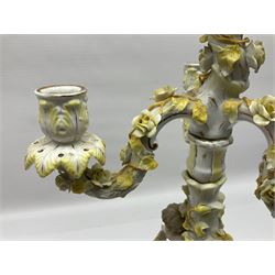 Dresden style candelabra, the central stem bordered by three branches, decorated with cherubs and yellow roses, H48cm