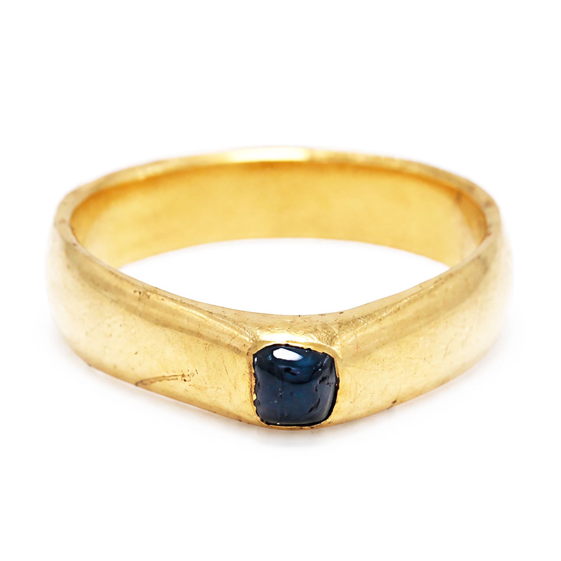 Medieval gold sapphire stirrup ring, circa. 1150-1500, the hoop of ‘D’ shaped cross-section, with raised triangular shaped bezel centred at the apex with a cabochon sapphire