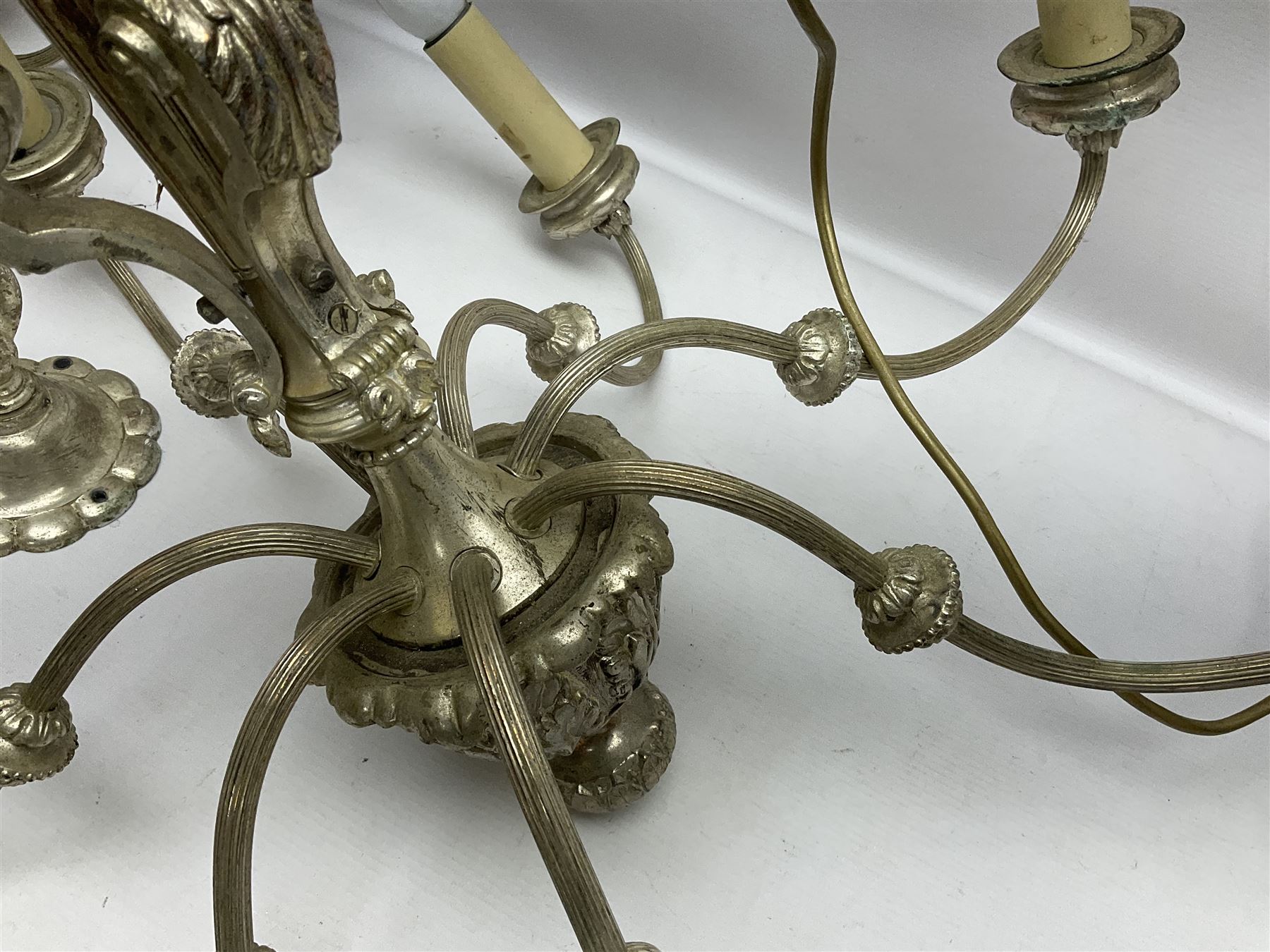 Siz branch silvered chandelier, decorated with acanthus leaves and putti, together with two matching three branch wall sconces, chandelier D65cm