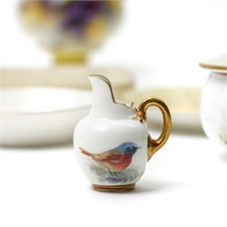 Nine hand-painted Royal Worcester items, comprising two trays painted with Worcester landscapes including 'Edgar Tower', a circular blush ivory tray painted with 'St Mary's Abbey - York', two trays and two covered trinket dishes painted with birds by Ernest Barker and H Powell, miniature jug painted by J Allen, and a Hadley Ware ewer, H11cm (9)