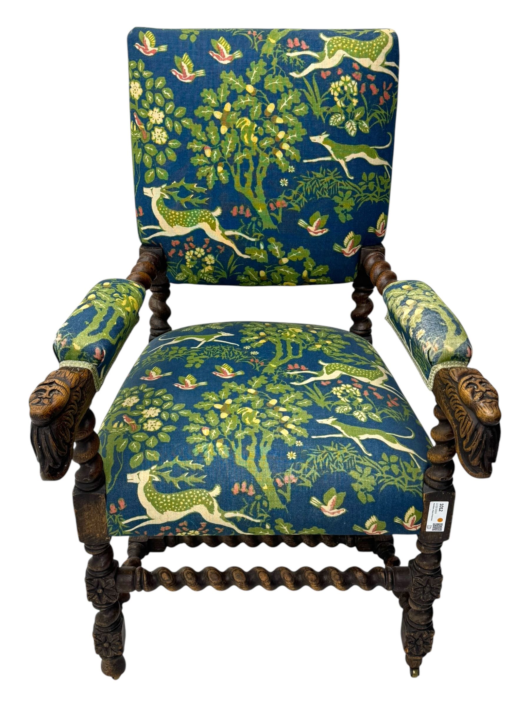 19th century Carolean design oak armchair, upholstered in a vibrant fabric depicting woodland and wildlife scenes, carved lion mask arm terminals, raised on barley twist supports united by H-stretcher