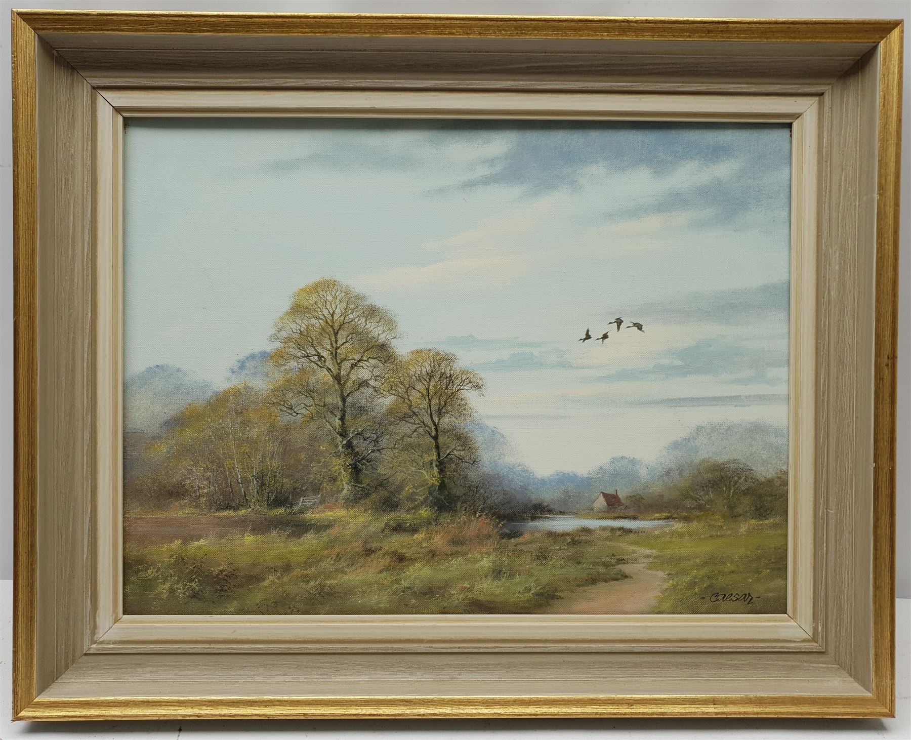 John Caesar Smith (British 1930-): Wooded Landscape with Geese in Flight, oil on canvas signed 29cm x 39cm