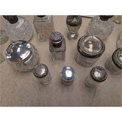 Collection of silver mounted glass bottles and jars, including decanter with etched floral decoration and silver collar, four scent bottles with silver caps, etc all hallmarked 