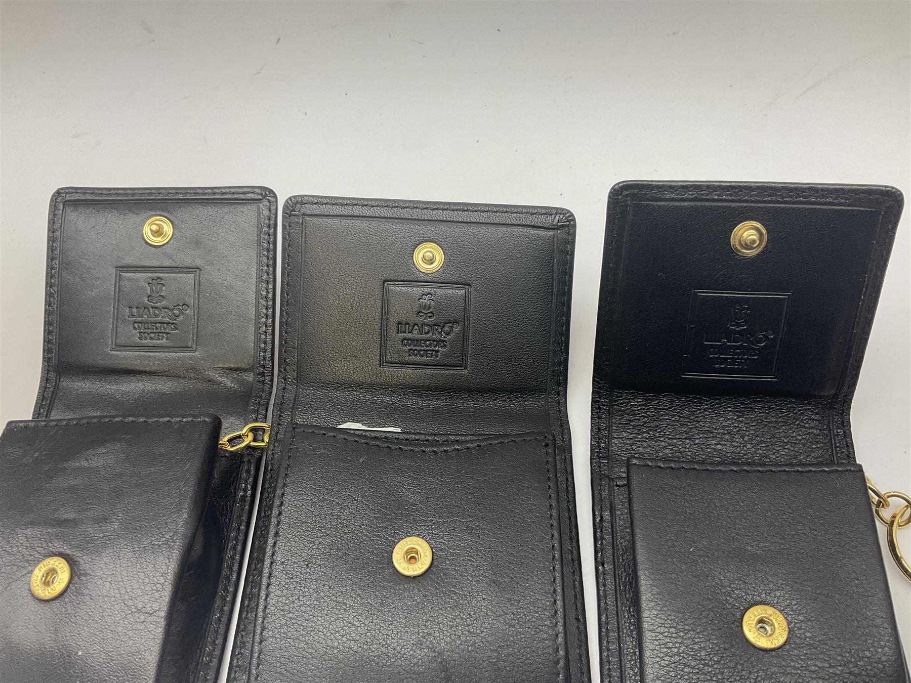 Lladro Collectors Society items, comprising of The Will to Create book, two candle holders; Sailing the Sea no 17665, Dolphins at Play no 17666, Plaque Bringing Us Together, key fob, leather wallet and a members joining pack with plaque, all in original boxes  