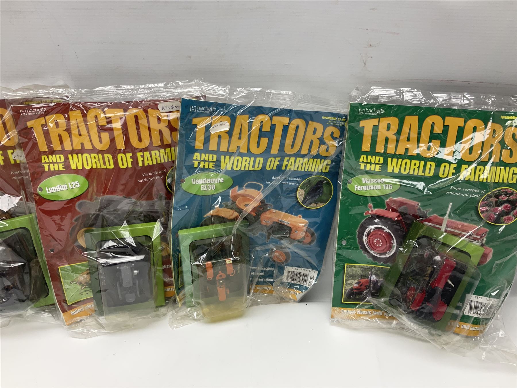Eighteen issues of Tractors and The World of Farming magazine, together with sixty diecast tractors, all in original packaging, in three boxes 