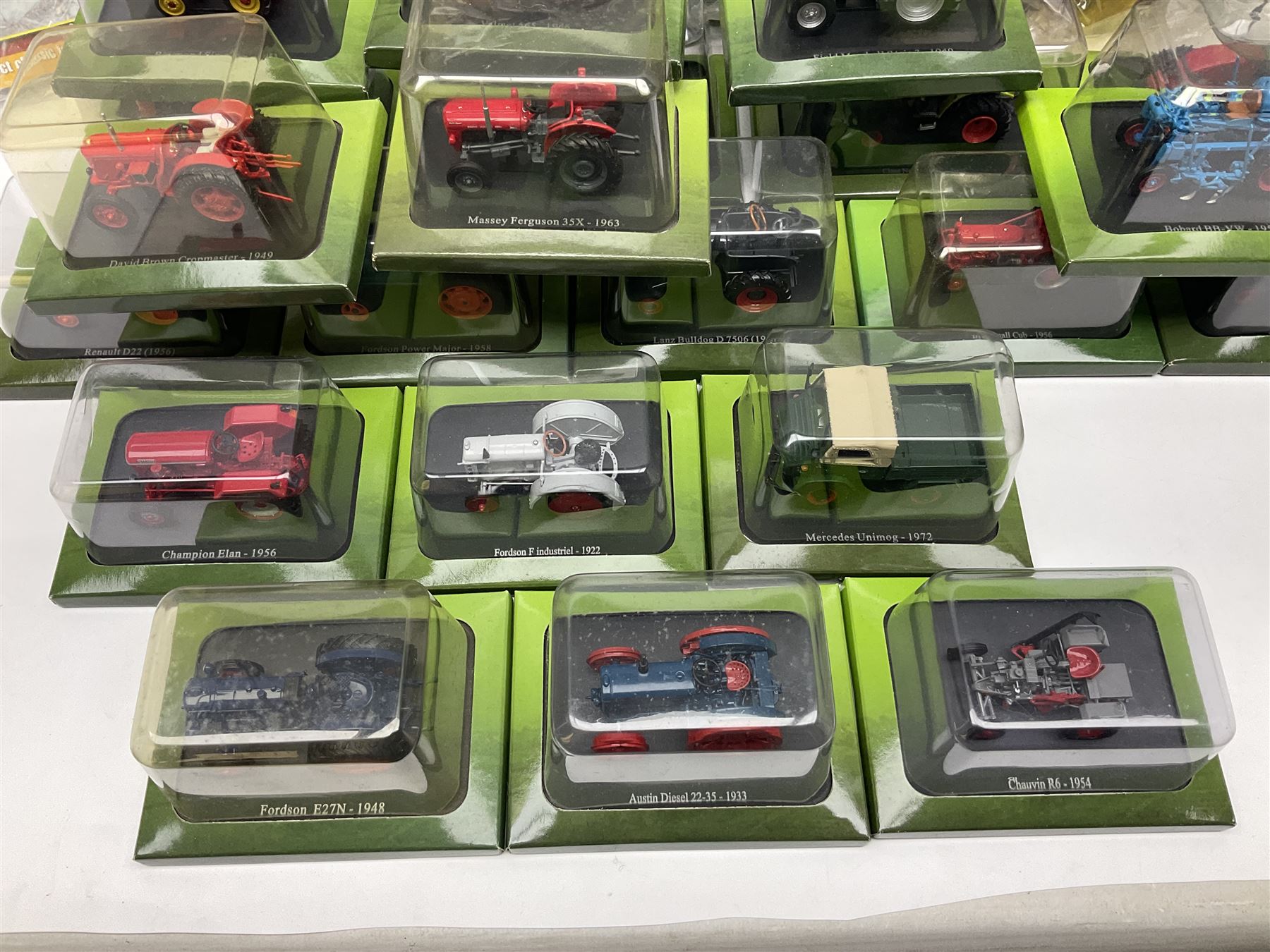Eighteen issues of Tractors and The World of Farming magazine, together with sixty diecast tractors, all in original packaging, in three boxes 