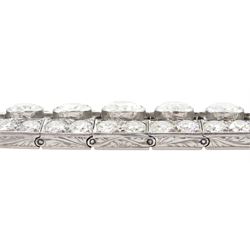 Continental Art Deco platinum old cut diamond openwork bracelet, circa 1920's, twenty-two bezel set graduating diamonds of approx 9.45 carat, the principal diamond approx 0.90, with a row milgrain set diamonds either side, the clasp set with a single diamond, the bracelet sides and clasp with engraved foliate decoration, total diamond weight approx 20.60 carat