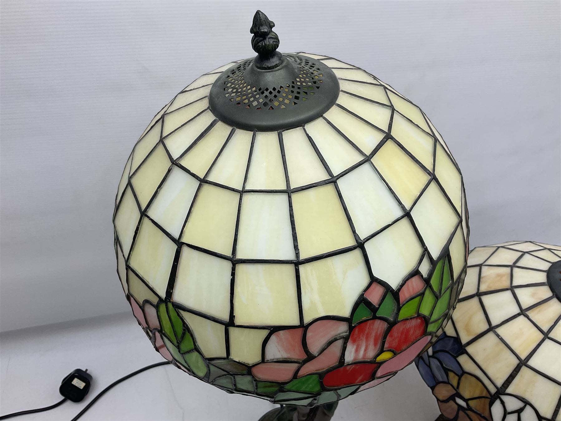 Tiffany style lamp in the form of a semi nude woman holding up a leaded lampshade together with a similar table lamp