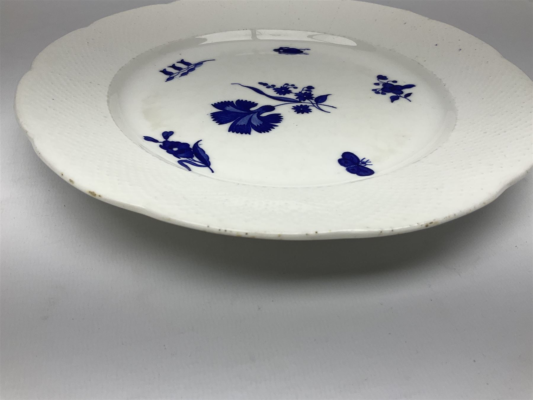 Three 19th century plates, comprising two circular examples and one oblong, each with osier moulded sides, the centres decorated in underglaze blue with Gillyflower type pattern, circular examples D25cm oblong example W27cm