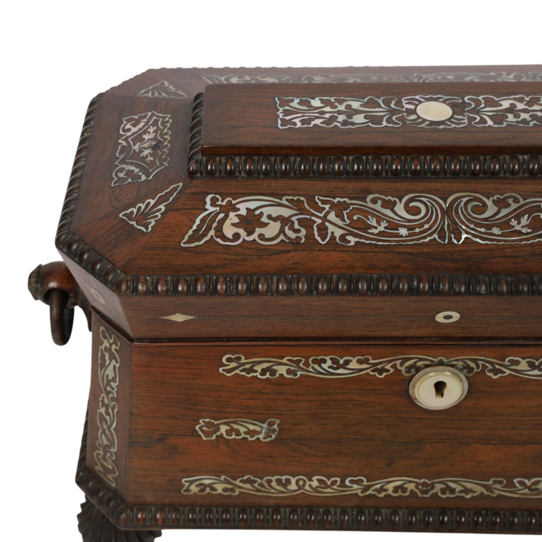 Tea caddy of sarcophagus form, inlaid with mother of pearl decoration,  the hinged lid opening to reveal two covered compartments, H24cm 